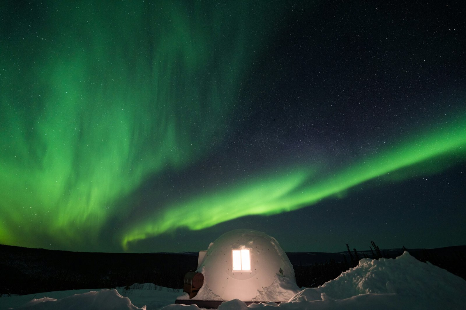 A glass igloo in Finland’s Lapland, glowing under the northern lights.