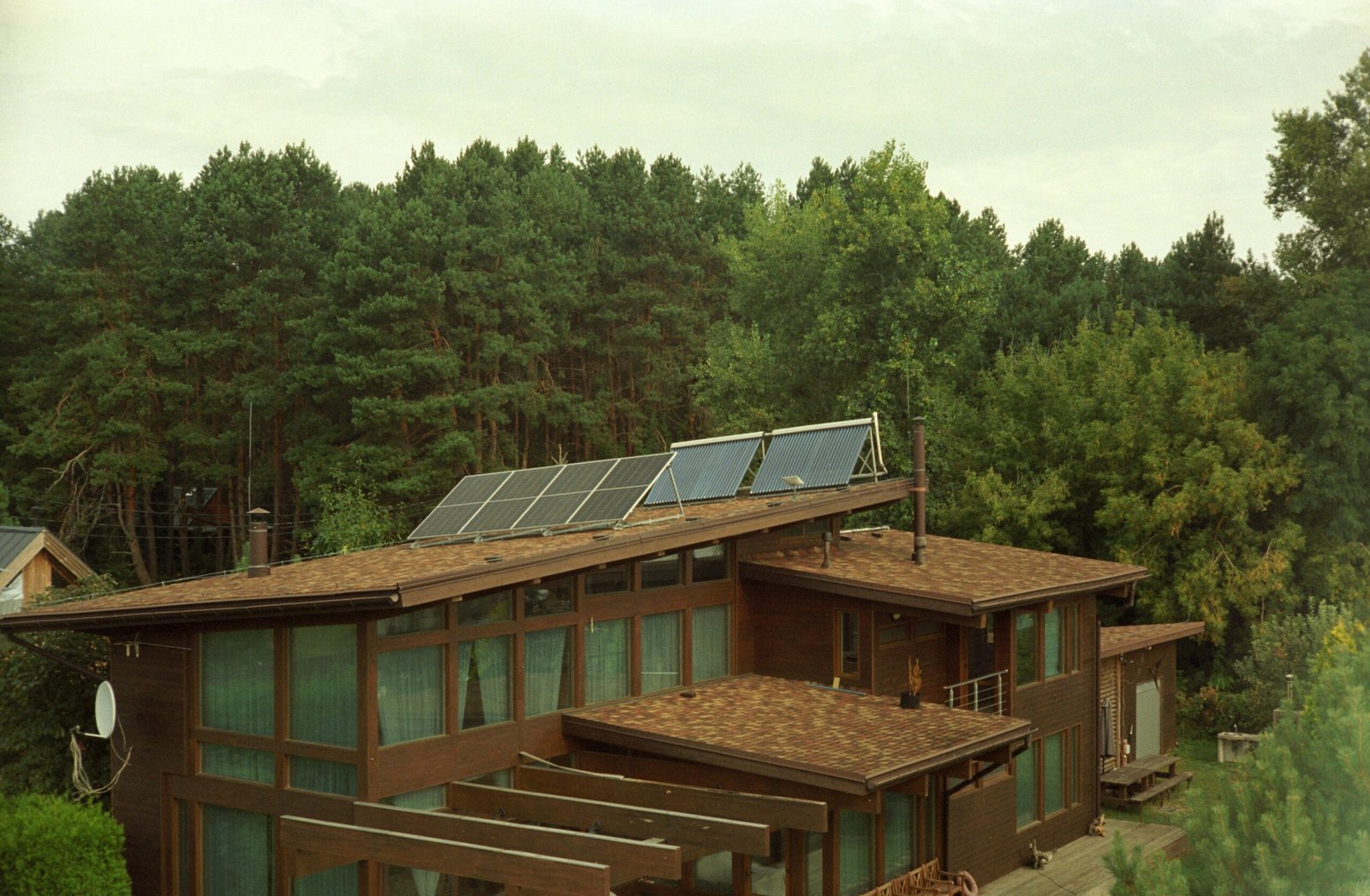 A sustainable eco-lodge in a forested area, showcasing renewable energy features like solar panels.