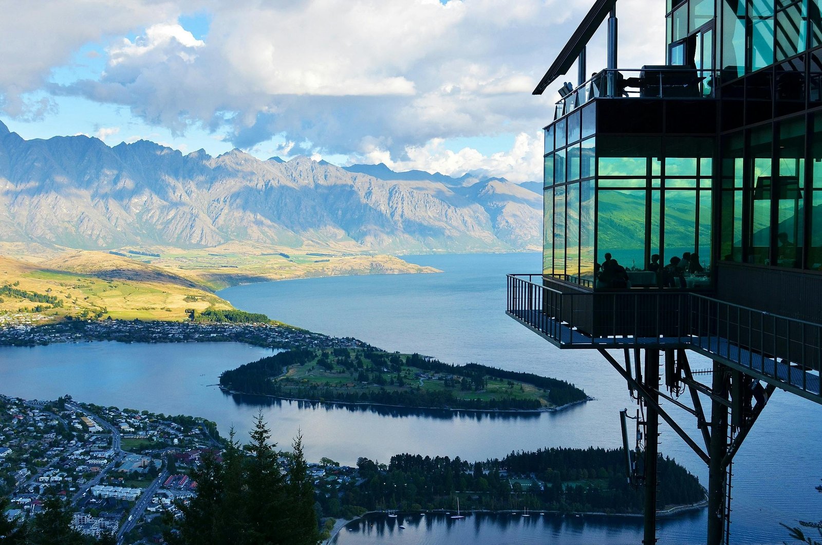 A scenic view of Lake Wakatipu in Queenstown, New Zealand, with the Remarkables mountain range in the background.