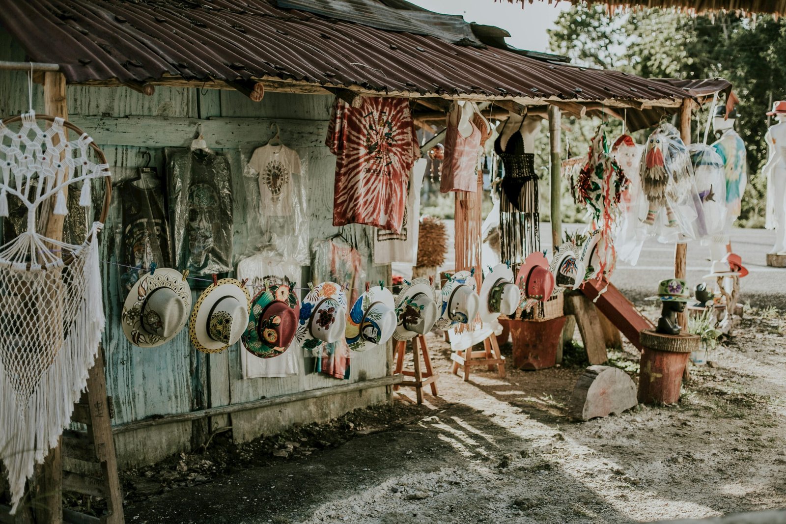 Artistic display of hats and clothes at a rustic outdoor market stall.