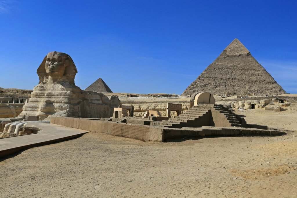 Stunning view of the Great Sphinx and Pyramid of Khafre in Giza, Egypt under clear blue skies.