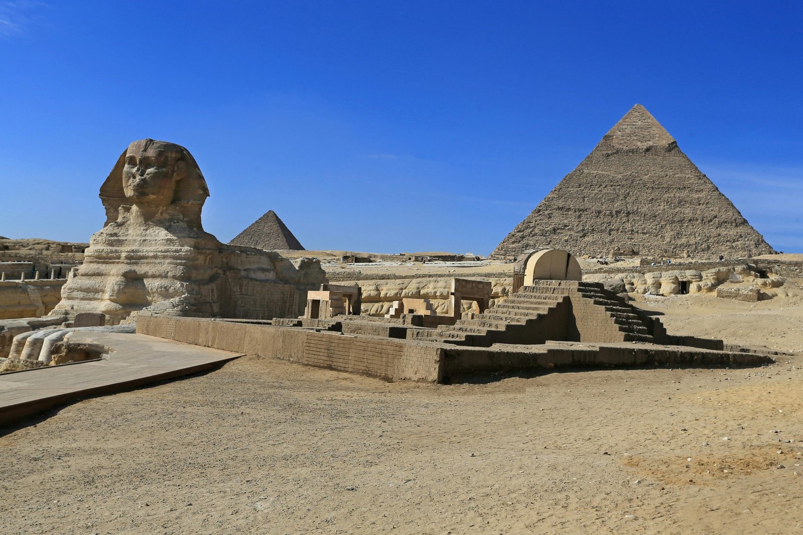 The Pyramids of Giza and the Great Sphinx under a clear blue sky, showcasing Egypt’s ancient history.