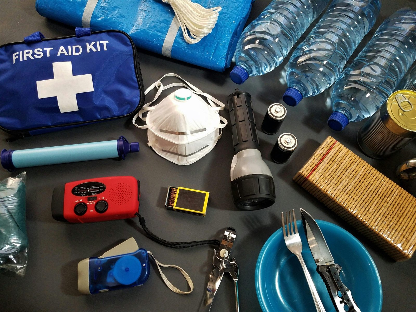 A travel first-aid kit with water bottle and hand sanitizer on a table.
