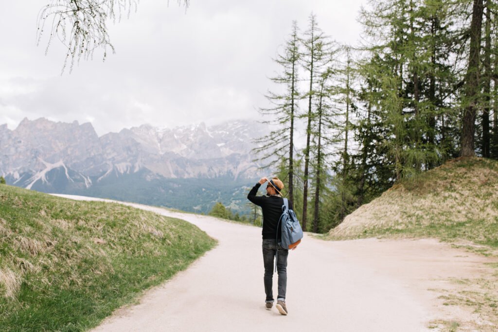 A traveler with a backpack walking confidently on a scenic path, symbolizing safe travel.