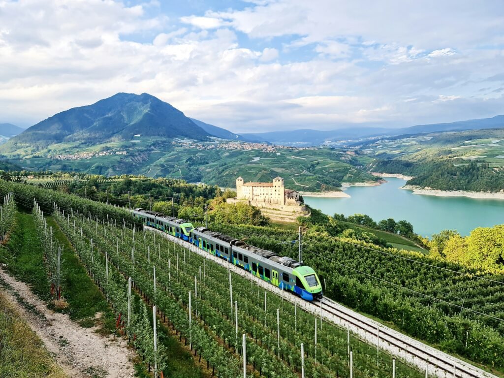 A sleek electric train traveling through a scenic European countryside, symbolizing sustainable summer travel.