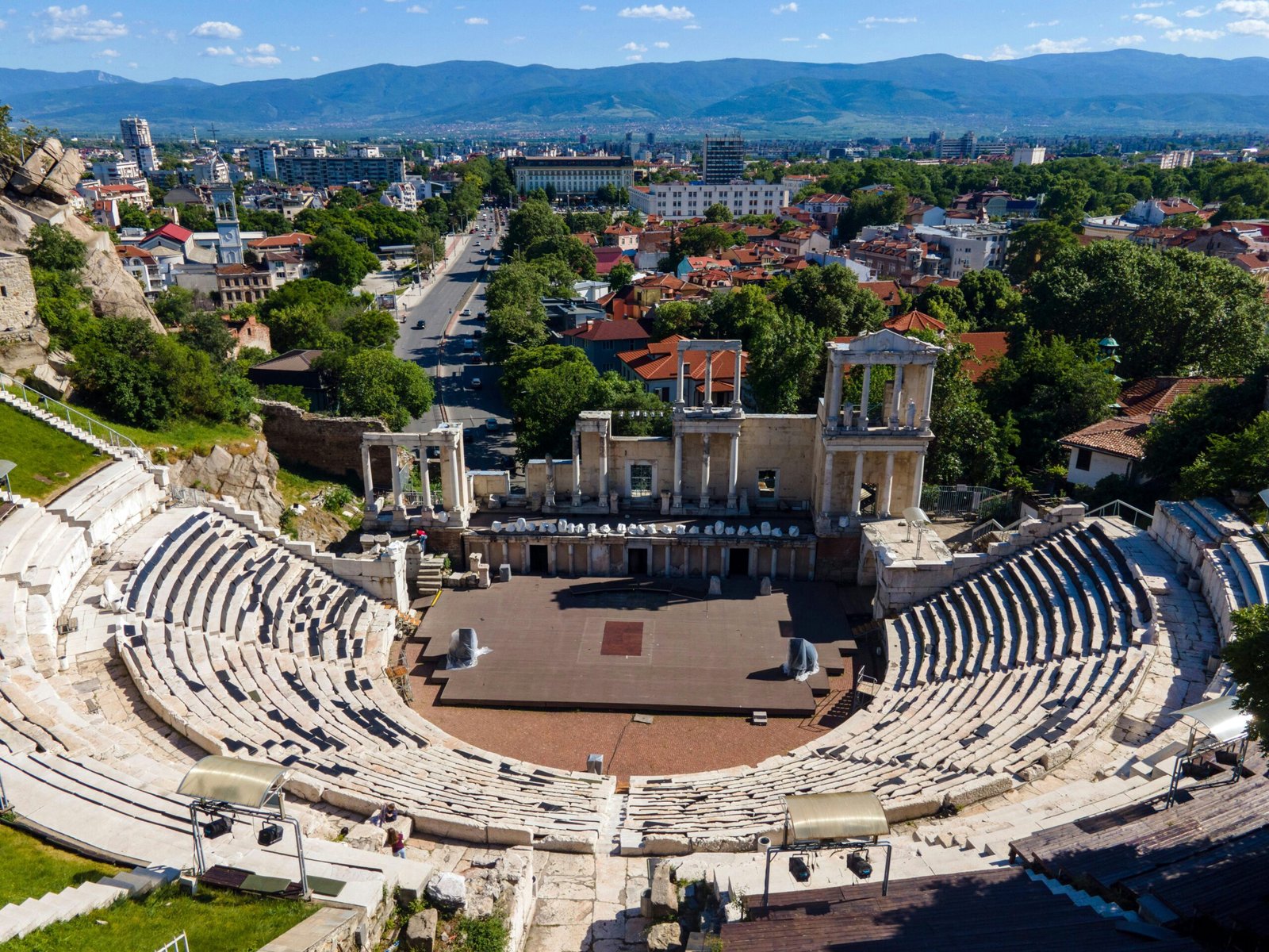 Stunning aerial view of the historic Roman Theatre in Plovdiv, Bulgaria, amidst urban landscape.