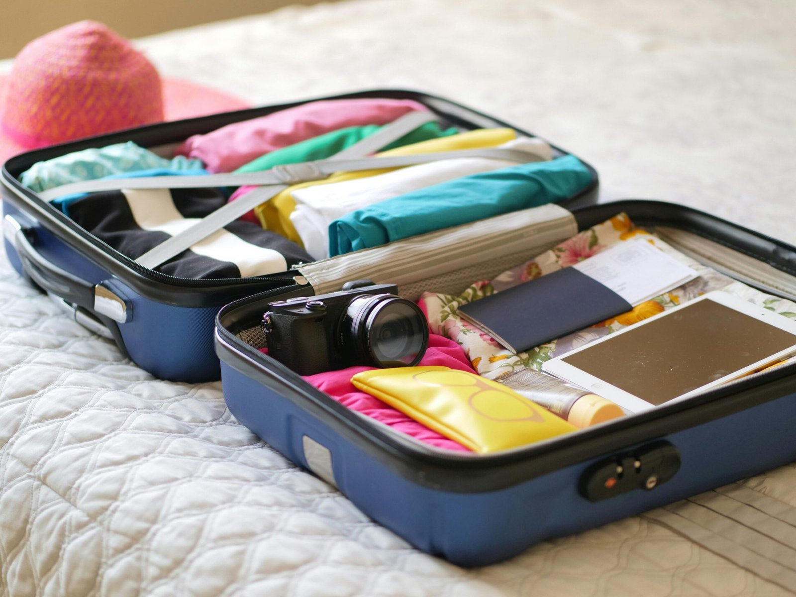 Well-organized travel packing setup showing tropical vacation essentials laid out on a bed or suitcase.
