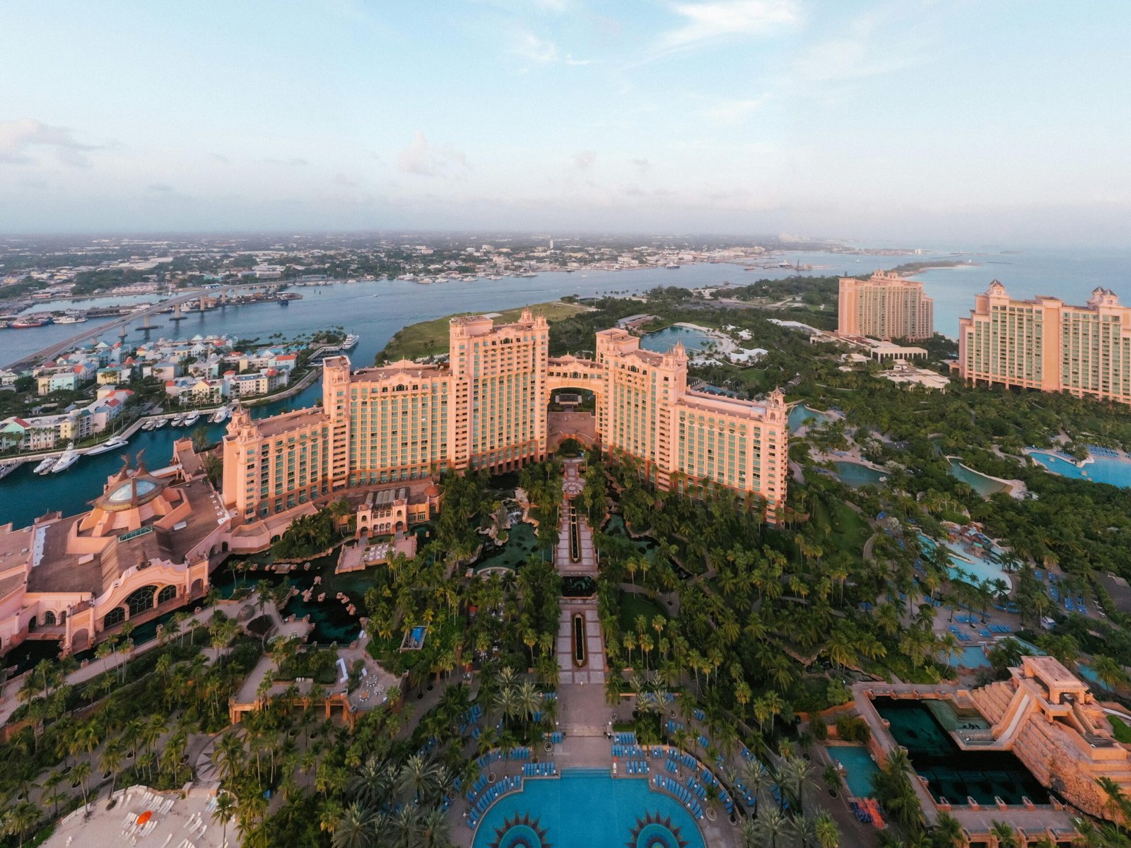 Aerial view of Nassau Harbor showing the contrast between colonial buildings and modern resort towers with cruise ships in the harbor.