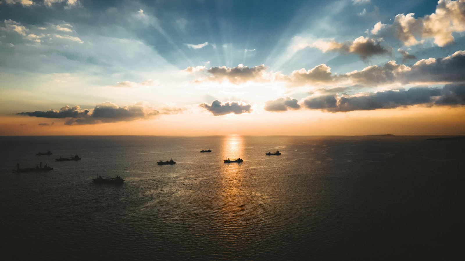 Breathtaking aerial view of ships on the ocean during a stunning sunset in Okinawa, Japan.