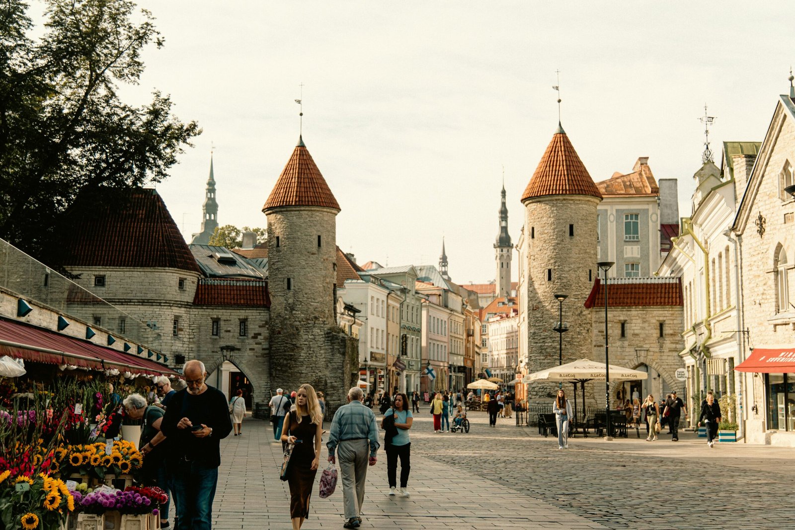 Medieval towers and cobblestone streets of Tallinn's Old Town with tourists in light jackets