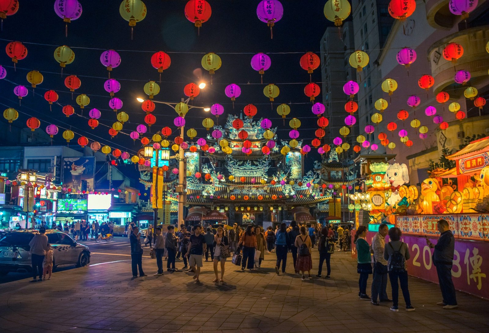 A vibrant night market scene in Taipei with colorful food stalls and lanterns