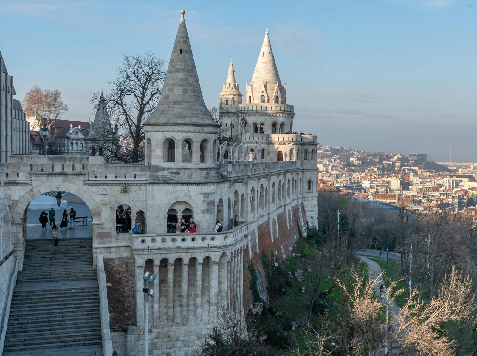 The iconic Fisherman's Bastion on Buda Hill in Budapest, with its fairytale-like white towers and arches framing a view of the Pest side.