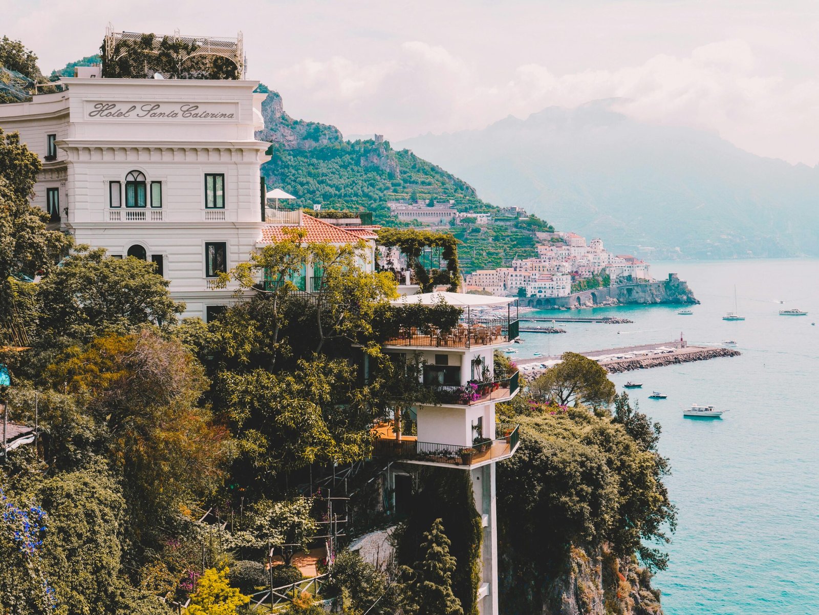 Stunning view of Amalfi Coast with cliffs, buildings, and boats. Perfect for travel and architecture lovers.