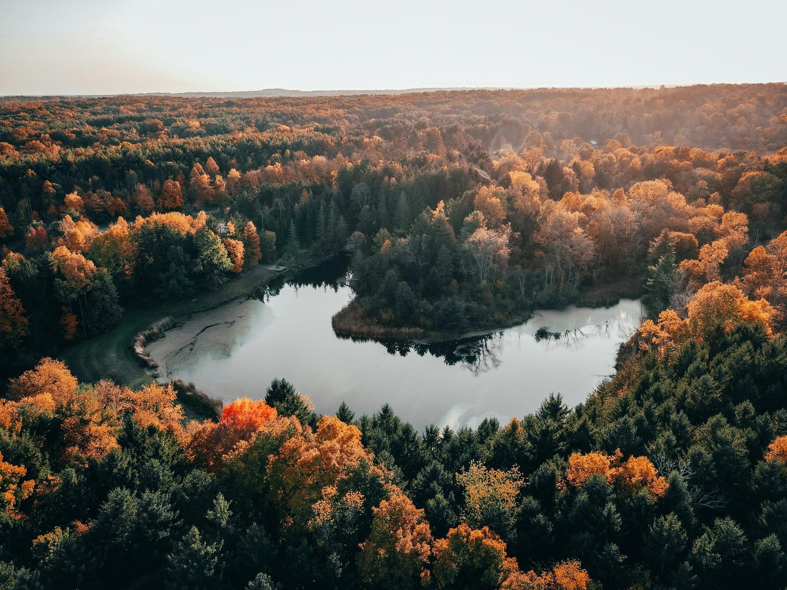 Stunning aerial view of autumn trees surrounding a calm lake in Peninsula, Ohio.