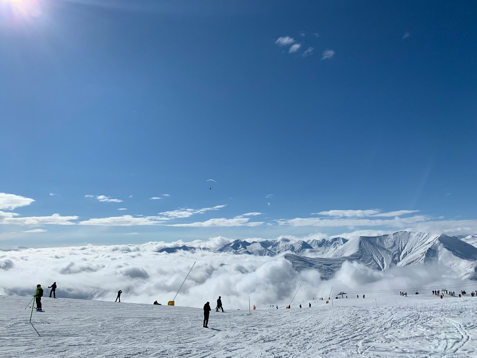 Skiers descending powder slopes with dramatic Big Sky mountain backdrop