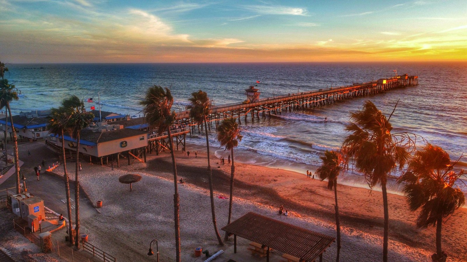 Peaceful beachfront cabin with palm trees at ocean view at sunset