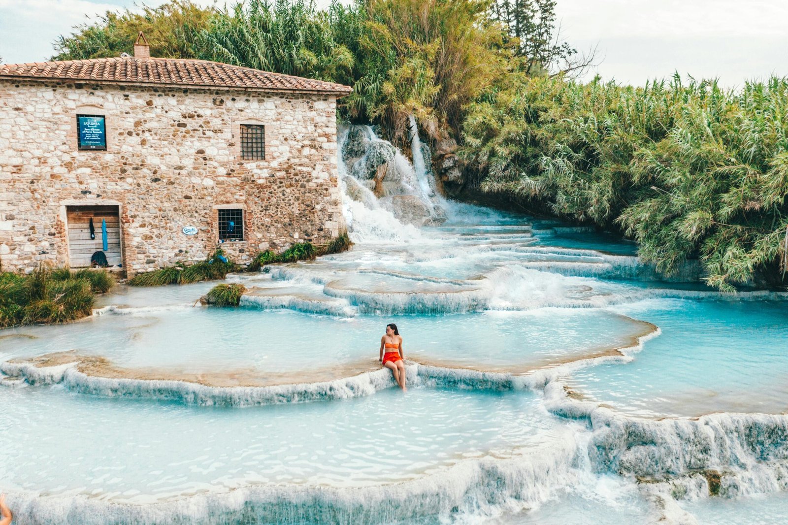 Natural thermal spa pools in Tuscany with steam rising at sunset
