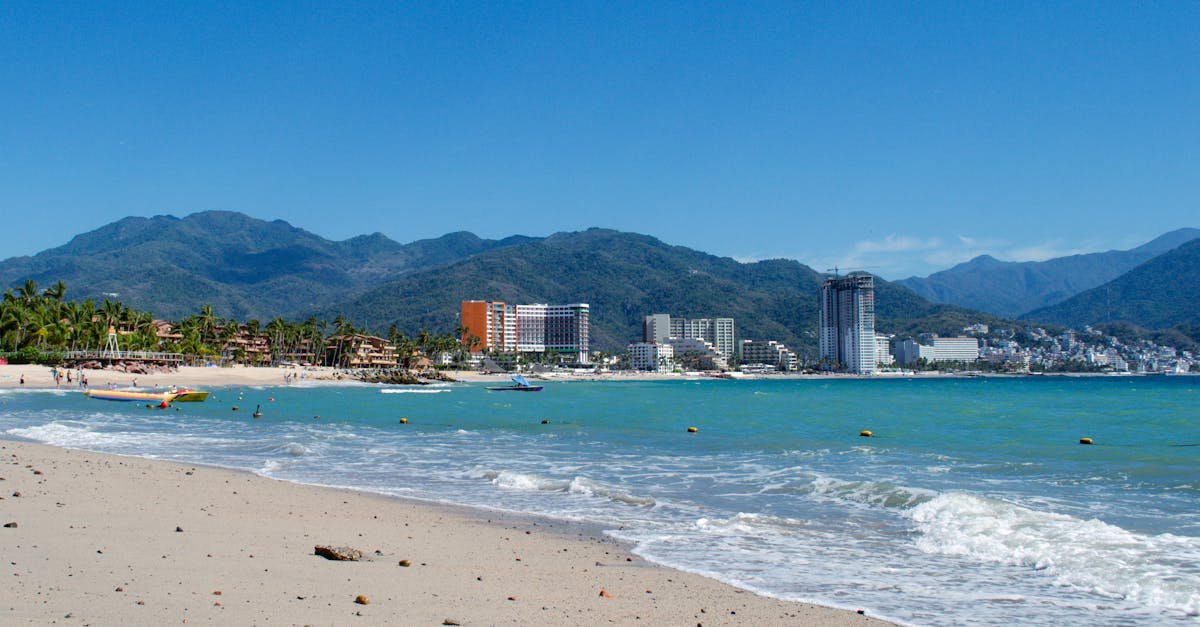 Beautiful beachfront with view of Puerto Vallarta city skyline and surrounding mountains.