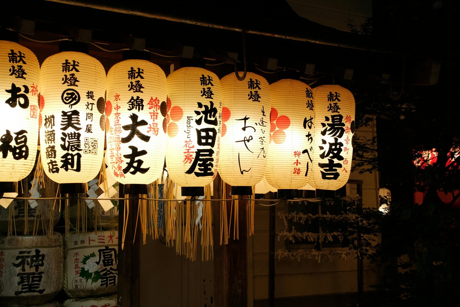 Illuminated traditional Japanese lanterns displayed at night, showcasing elegant calligraphy.